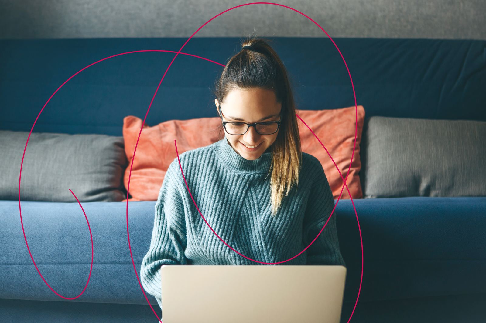 A woman smiling as she works through her finances on a laptop